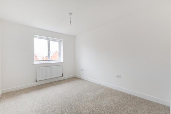A room with a window and a radiator on the wall.
