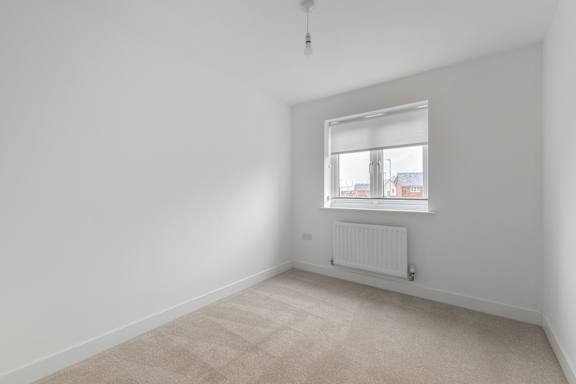 A room with a window and a radiator on the floor.
