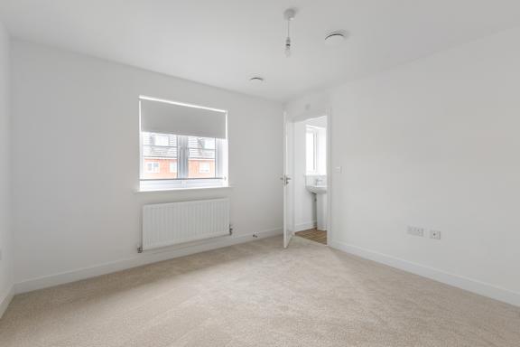 A white room with a window and a radiator.