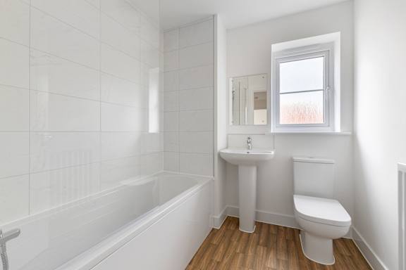 A white bathroom with a tub, toilet, and sink.