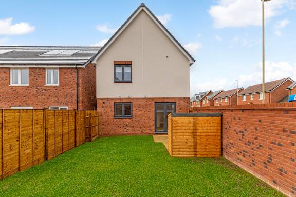 A house with a brown fence and a green lawn.