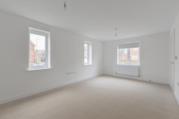 Empty room with two windows and a radiator.