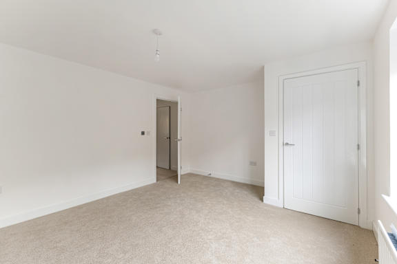 A white room with a carpeted floor and two doors.