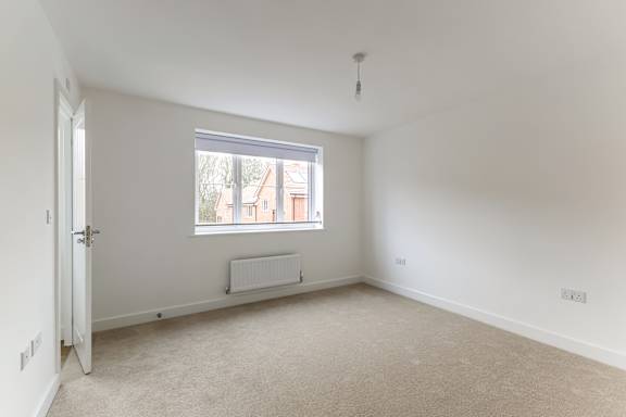 A room with a window and a radiator on the floor.
