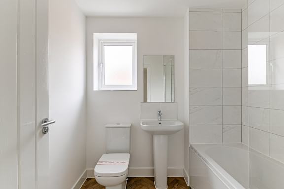 A white bathroom with a toilet, sink, and bathtub.