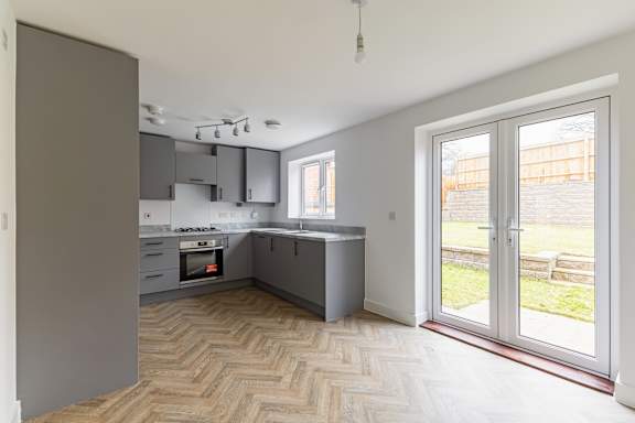 A kitchen with a wooden floor and a window.