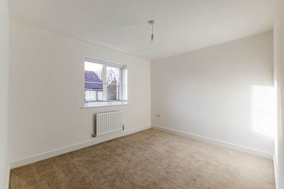 A room with a window and a radiator on the floor.