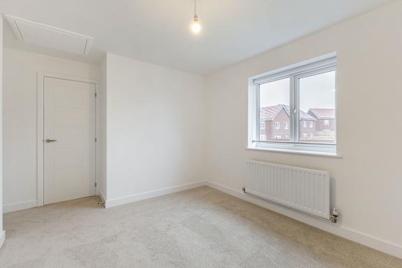 A room with a window and a radiator on the wall.