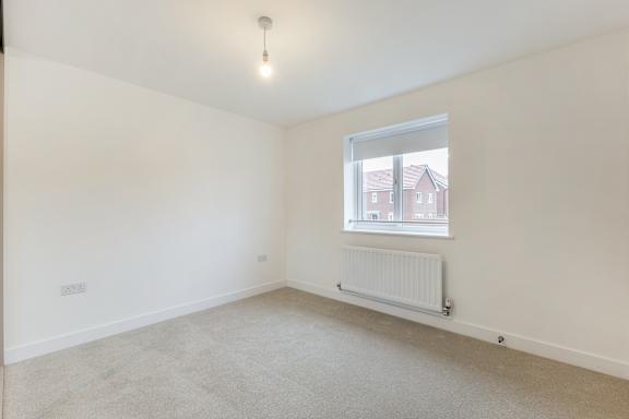A room with a window and a radiator on the floor.