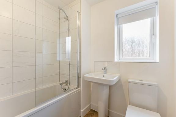 A white bathroom with a sink, toilet, and tub.