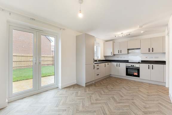 A spacious kitchen with a herringbone patterned floor.