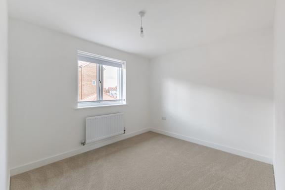 A room with a window and a radiator on the wall.
