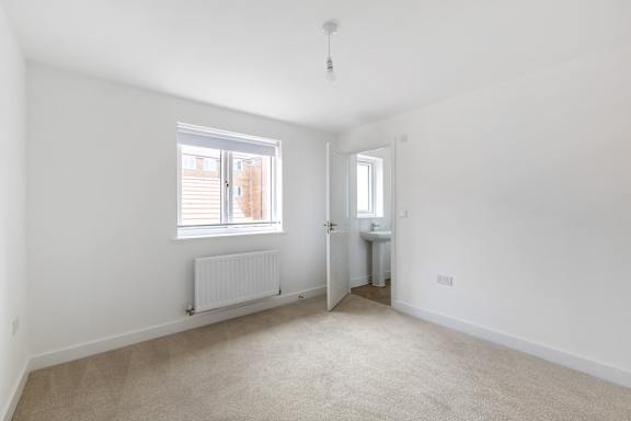 A white room with a window and a radiator.
