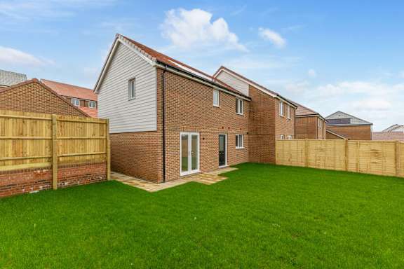 A house with a brown fence and a green lawn.