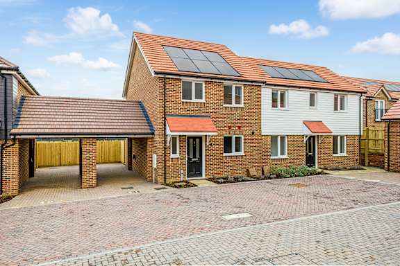 A house with a red roof and solar panels on the roof.