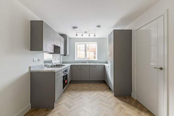 A kitchen with a white door and a window.
