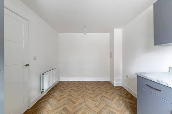 A room with a wooden floor and white walls.