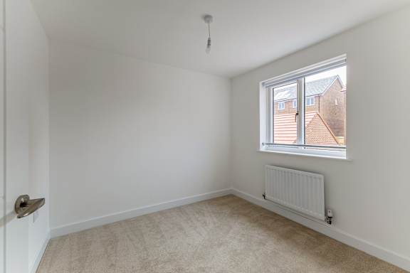 A room with a window and a radiator on the wall.