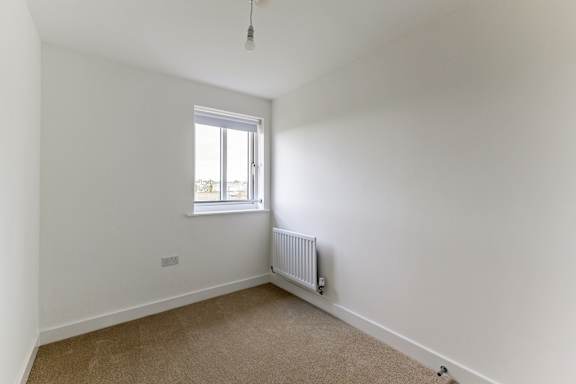 A room with a window and a radiator on the wall.