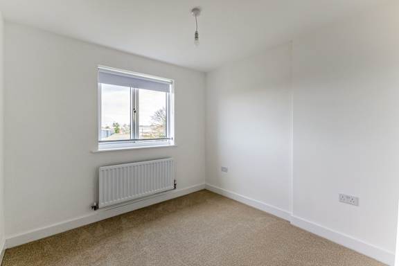 A room with a window and a radiator on the wall.