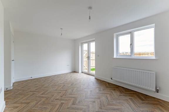 A room with a wooden floor and a window.