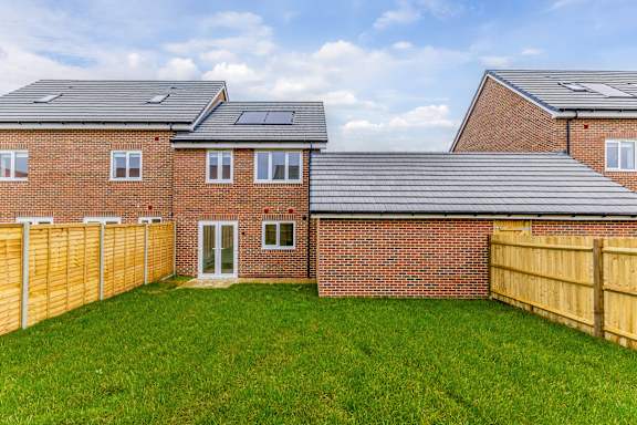 A house with a grey roof and a wooden fence.