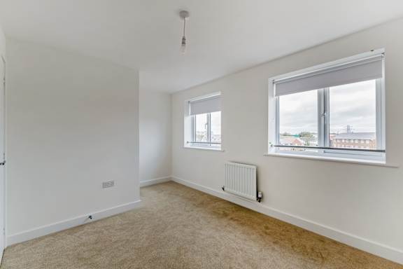 A room with a window and a radiator on the wall.