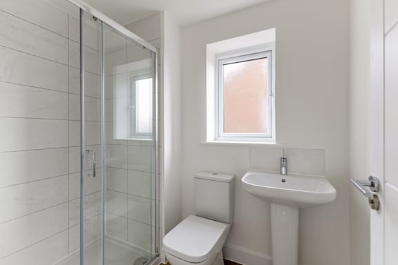 A white toilet sits next to a white sink in a bathroom.