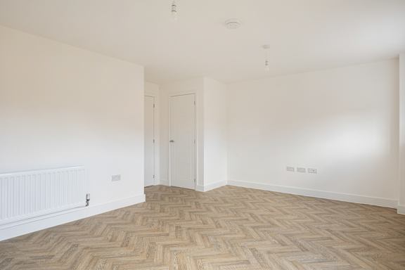 A room with a wooden floor and white walls.