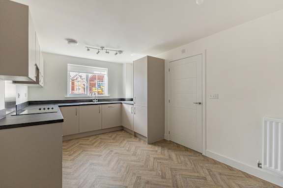 A kitchen with a black counter top and white cabinets.