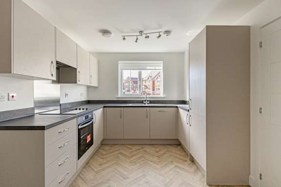 A kitchen with a black countertop and white cabinets.
