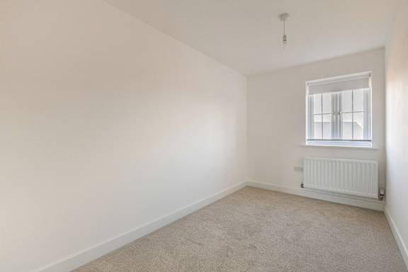 A room with a window and a radiator on the wall.