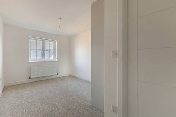 A room with a window and a radiator on the wall.