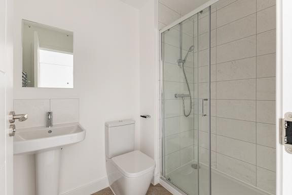 A white toilet sits next to a sink in a bathroom.