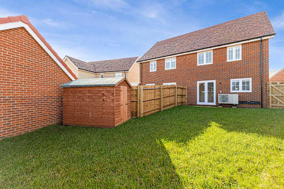 A red brick house with a green lawn in front.