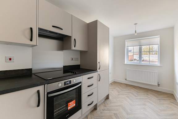 A kitchen with a black countertop and white appliances.