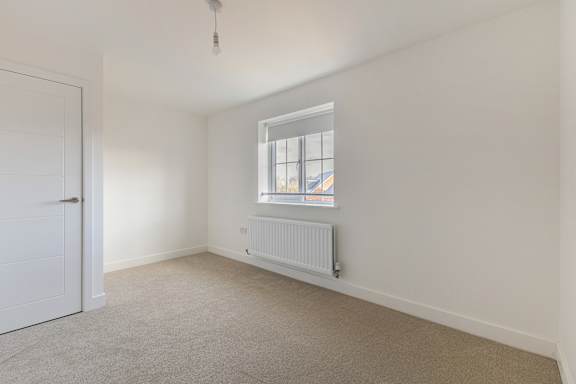 A room with a window and a radiator on the wall.