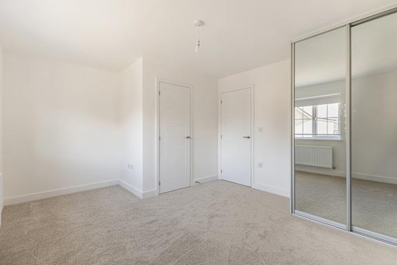 A room with white walls and a carpeted floor with a glass door.