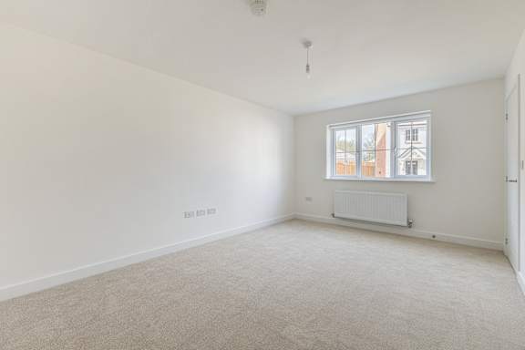 A room with a window and a radiator on the wall.