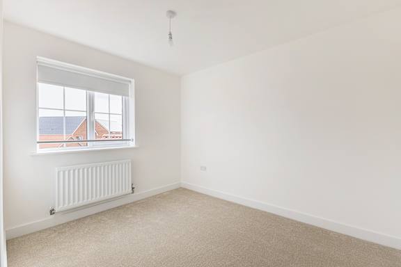A room with a window and a radiator on the wall.