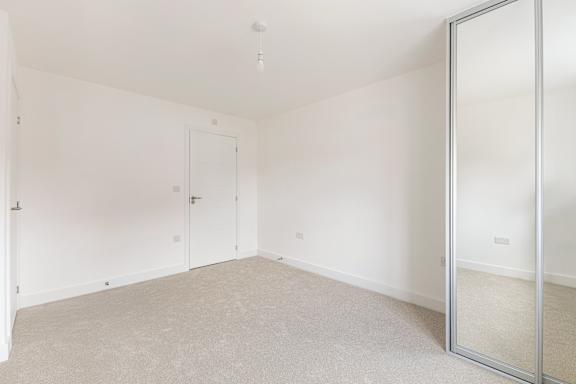 A room with a carpeted floor and a glass door.