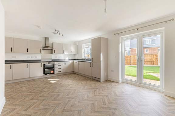A spacious kitchen with a herringbone patterned floor.