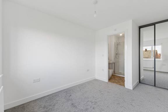 A room with a carpeted floor and a white wall.