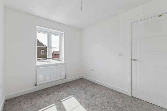 A room with a window and a white door.