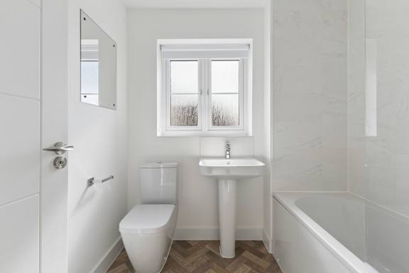 A white bathroom with a toilet, sink, and tub.