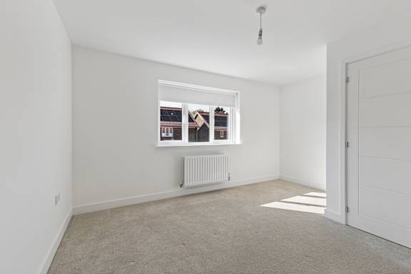 A white room with a window and a radiator.