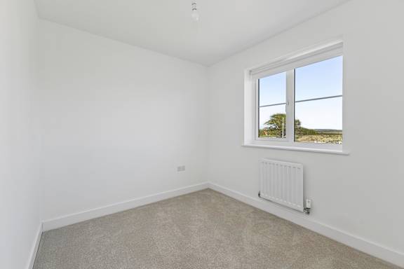 A room with a window and a radiator on the wall.