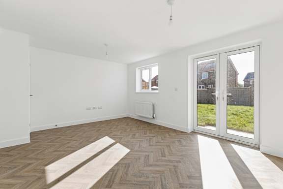 A room with a wooden floor and a sliding glass door.