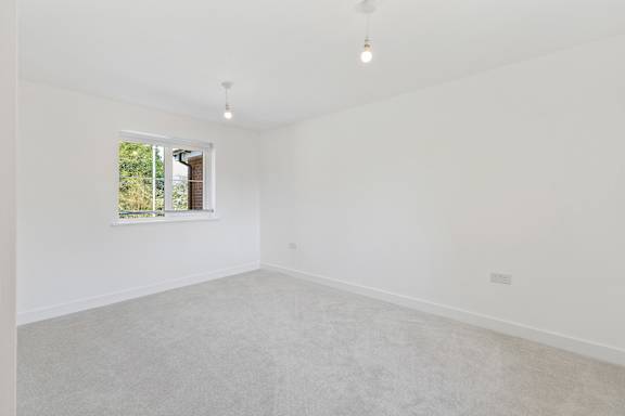 A white room with a window and a picture on the wall.