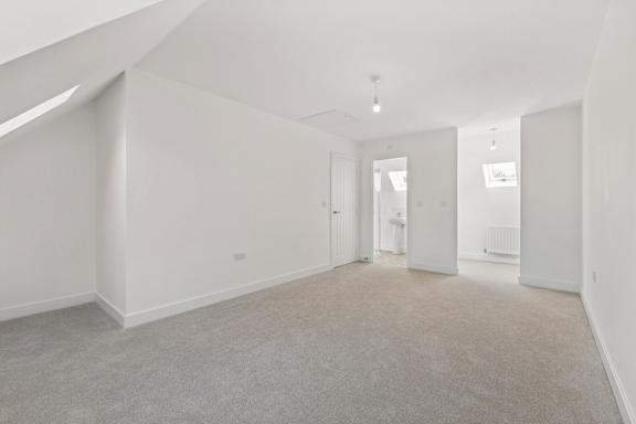 Empty room with white walls and carpeted floor.